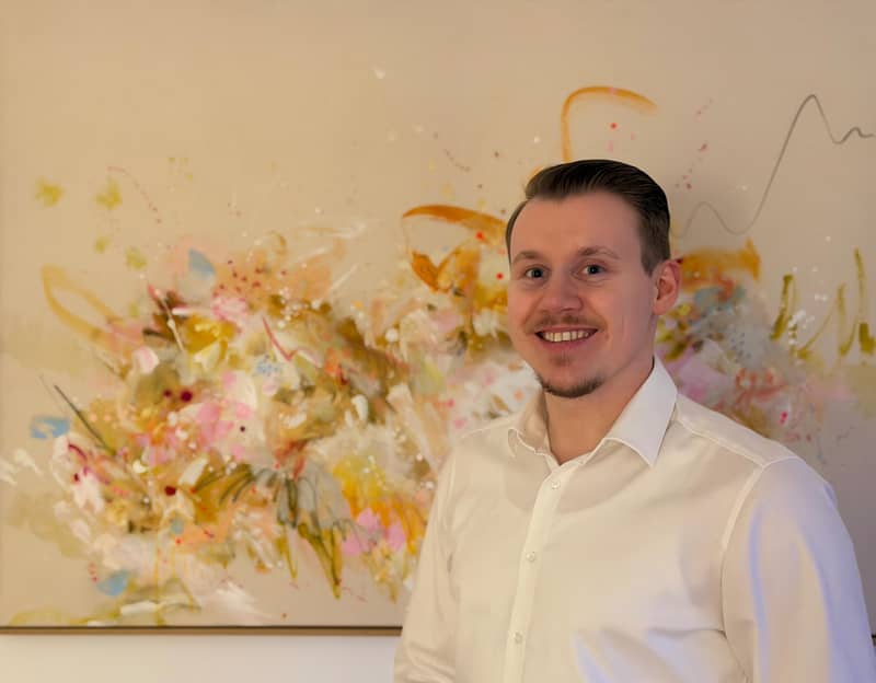 Psychotherapeut Michael Odenthal stehend vor einem schönen bunten Wandbild