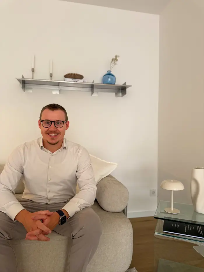 Psychotherapeut Michael Odenthal sitzend vor einem bunten Bild an der Wand